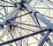 Gray or white metal ferris wheel with closed passenger cabins close-up in the amusement park