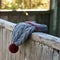 Gray winter hat with a jacquard pattern on a wooden background