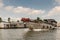 Gray wooden barge sails Kinh 28 canal in Cai Be, Mekong Delta, Vietnam