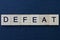 Gray word defeat of square wooden letters