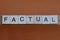 Gray word factual made of wooden square letters