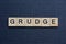 Gray word grudge from small wooden letters