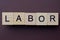 gray word labor from small wooden letters