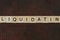 Gray word liquidating made of wooden square letters