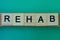 Gray word rehab made of wooden square letters