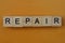 Gray word repair made of wooden square letters