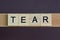Gray word tear made of wooden square letters