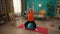 A grayhaired retired woman sitting on a fitness ball performs an exercise with dumbbells. An elderly woman raises