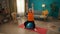 A grayhaired retired woman sitting on a fitness ball performs an exercise with dumbbells. An elderly woman raises