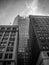 Grayscale low angle shot of high rise city buildings against a cloudy sky in San Francisco