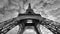 Grayscale low angle shot of the historic Eiffel tower under the gloomy sky