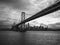 Grayscale photo of San Franciscoâ€“Oakland Bay Bridge over a body of water