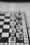 Grayscale shot of a chessboard with the focus on white\\\'s rook and pawn