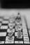 Grayscale shot of a chessboard with the focus on white\\\'s rook and pawn