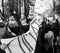 Grayscale shot of a group of angry COP26 protestors marching in the streets of Glasgow, Scotland