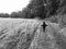 Grayscale shot of a lost little boy running around in a vast field in the countryside alone