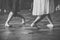 Grayscale shot of male and female feet in a dancing position on a wooden floor