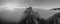 Grayscale shot of the mysterious Srebrenik fortress in fog, picturesque cloudscape in the background