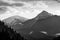 Grayscale shot of snowcap mountains against cloudy sky background