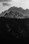 Grayscale shot of snowcap mountains against cloudy sky background