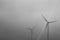 Grayscale shot of windmills under a cloudy sky - sustainable climate visuals