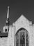 Grayscale view of unique church with tall steeple