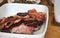 Greasy fried bacon and sausages on a ceramic plate - typical English breakfast