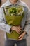 Great bouquet of green hydrangea with sprigs of gypsophila in wrapping paper in female hands