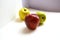 A great composition of three fresh and shiny green, red and yellow apples with red apples masking the rest of the apples on a whit