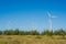 Great concept of renewable, sustainable energy. Wind field with wind turbines, producing aeolian energy under blue sky