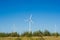 Great concept of renewable, sustainable energy. Wind field with wind turbines, producing aeolian energy under blue sky