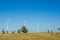 Great concept of renewable, sustainable energy. Wind field with wind turbines, producing aeolian energy under blue sky