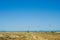 Great concept of renewable, sustainable energy. Wind field with wind turbines, producing aeolian energy under blue sky