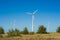 Great concept of renewable, sustainable energy. Wind field with wind turbines, producing aeolian energy under blue sky