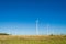 Great concept of renewable, sustainable energy. Wind field with wind turbines, producing aeolian energy under blue sky