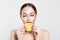 Great food for a healthy lifestyle. Beautiful young shirtless woman holding  having a slice piece of orange in her mouth while