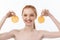 Great food for a healthy lifestyle. Beautiful young shirtless woman holding piece of orange standing against white