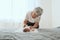 Great-grandmother plays with a newborn great-granddaughter. The baby lies in the arms of the grandmother