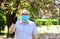 Great idea. man at sakura in protective mask. smell blooming flowers on coronavirus quarantine. observe precautions