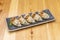 great Japanese dumplings, gyozas, grilled fried stuffed with meat and served with wakame seaweed on a black plate