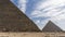 The Great Pyramids of Giza: Cheops and Chephren against a background of blue sky and clouds