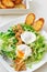 Great Salade Lyonnaise, French classic salad. Eggs, bacon, toasts.