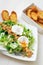 Great Salade Lyonnaise, French classic salad. Eggs, bacon, toasts.