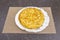 great Spanish omelette with eggs and potatoes with onion on a pastry tray with perforated paper
