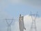 Great statue of Jesus Christ seen between two power transmission towers. Mysticism and Technology.