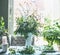 Great summer wild flowers bunch in white vase on table in living room at window . Home lifestyle