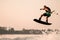 great view of active muscular man making trick and jump with wakeboard on sky background.