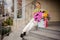 great view of bouquet of different multi-colored flowers in box on steps and woman nearby