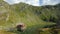 Great view of mountain cottage on alpine lake shore