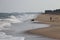 The great water wave on sea against clear sky with blurry two black dog playing on sandy and beach background, beach and sky